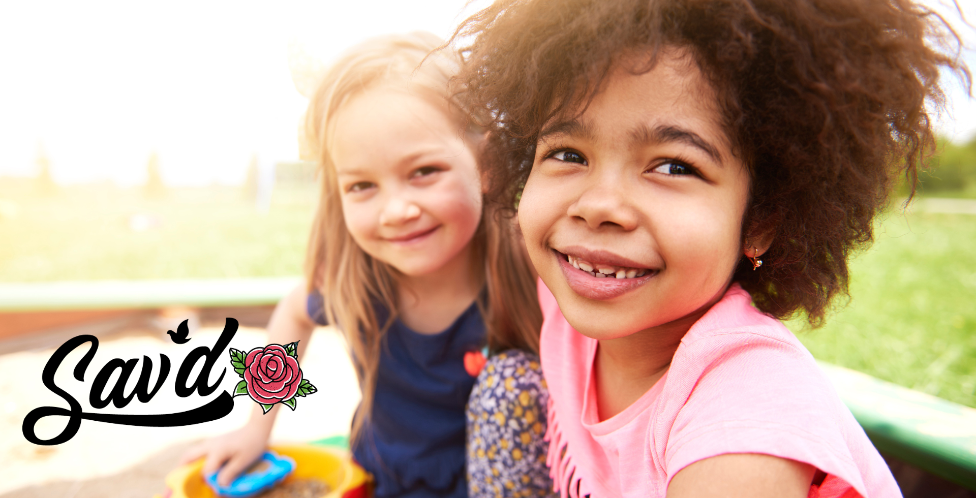 Joyful girls laughing and playing together in a vibrant playground, enjoying the colorful equipment and sunny outdoor atmosphere.